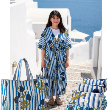 kit voyage paris sur une table en vacances avec sac cabas, trousses de toilette, caftan